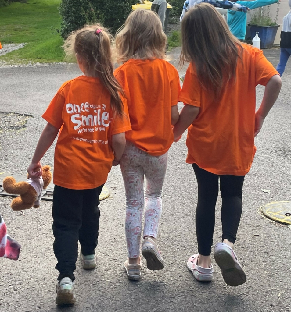 3 children holding hands walking away together