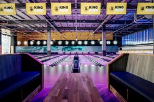 A bowling lane lit in pink lighting