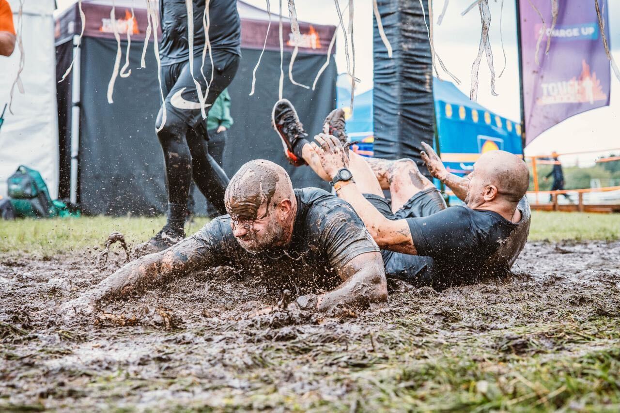 A person covered in mud on the floor